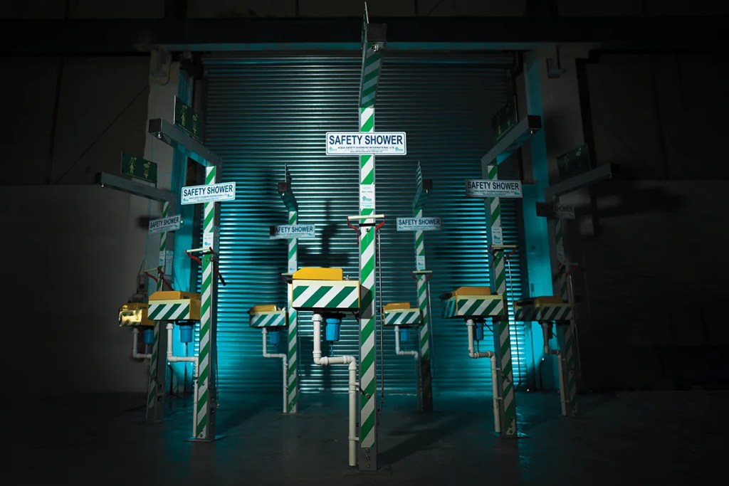 7 emergency safety showers line up against roller shutters. Cinematic blue lighting for videos